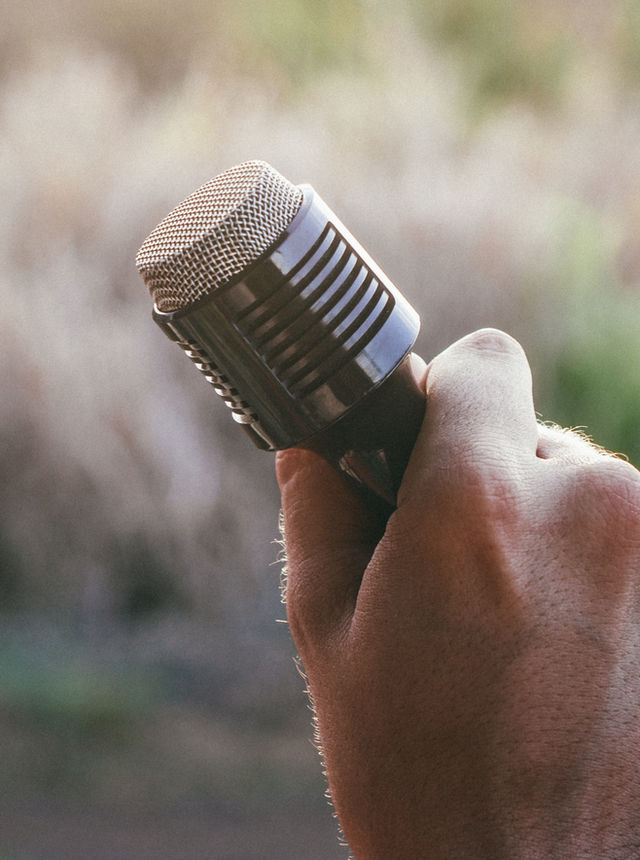 A hand holding a microphone